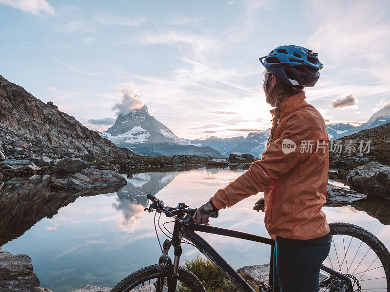 女山地自行车手欣赏马特洪湖下面的Riffelsee湖的景色