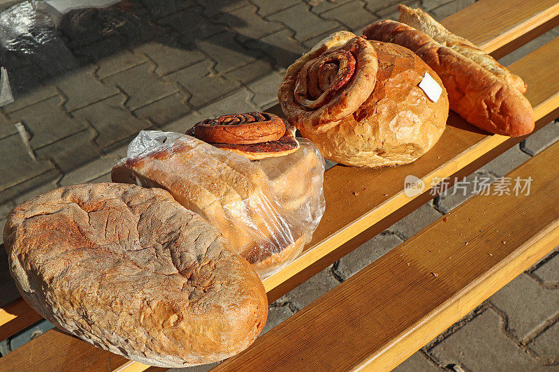 干瘪的面包和法式面包放在户外的长凳上