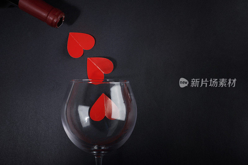 红桃从酒瓶里倒出来。情人节的背景