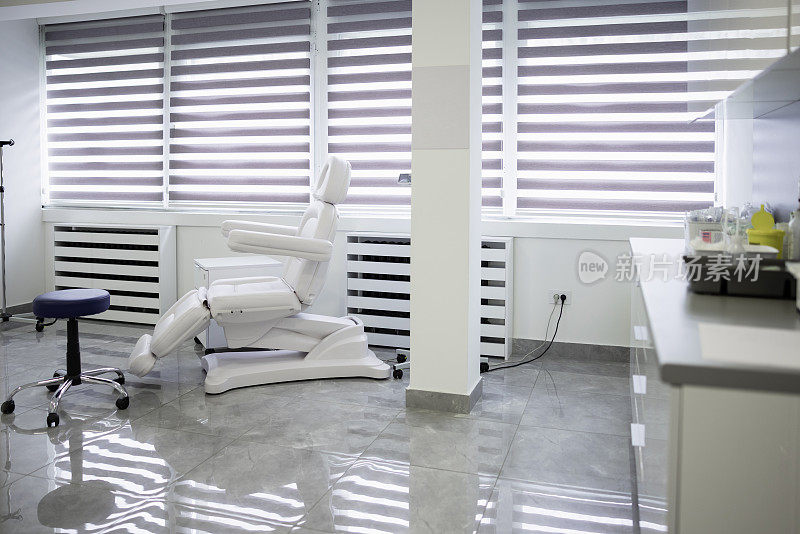 现代化的医生办公室，白色的椅子，窗帘的窗户