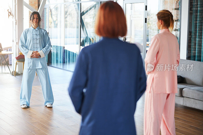 穿着中国服装的妇女和她们的主人一起练习