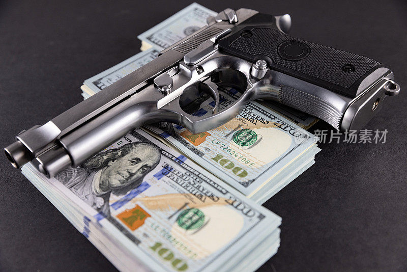 手枪对美元的堆积-犯罪金钱的概念