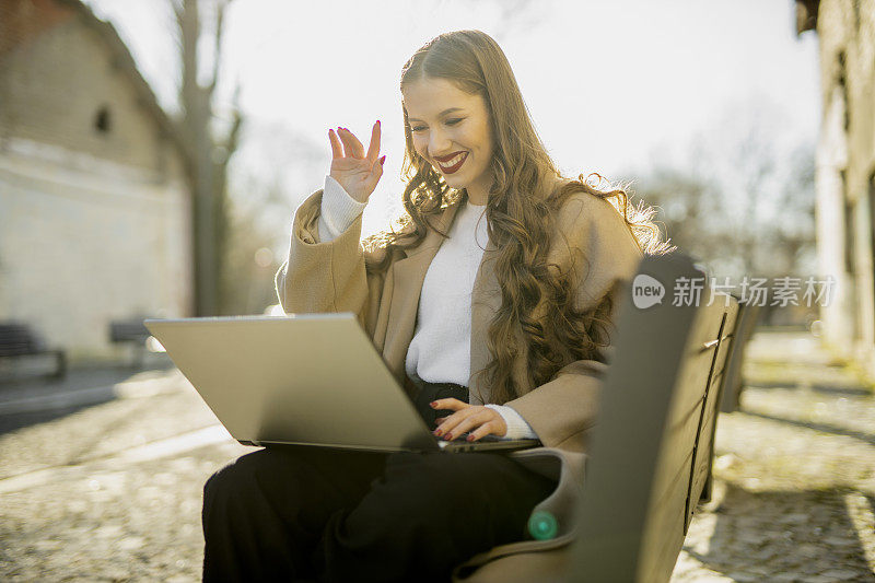 成功的年轻女性使用她的笔记本电脑和户外工作