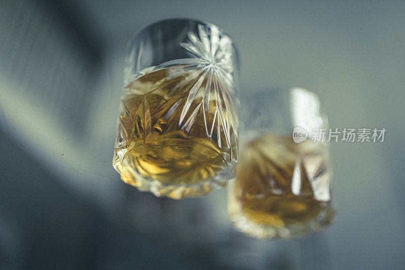 低角度烈酒，透过一张玻璃桌子，两杯加冰的苏格兰威士忌。