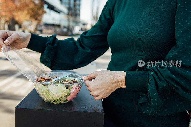 一个陌生的女人在塑料盒里吃午饭