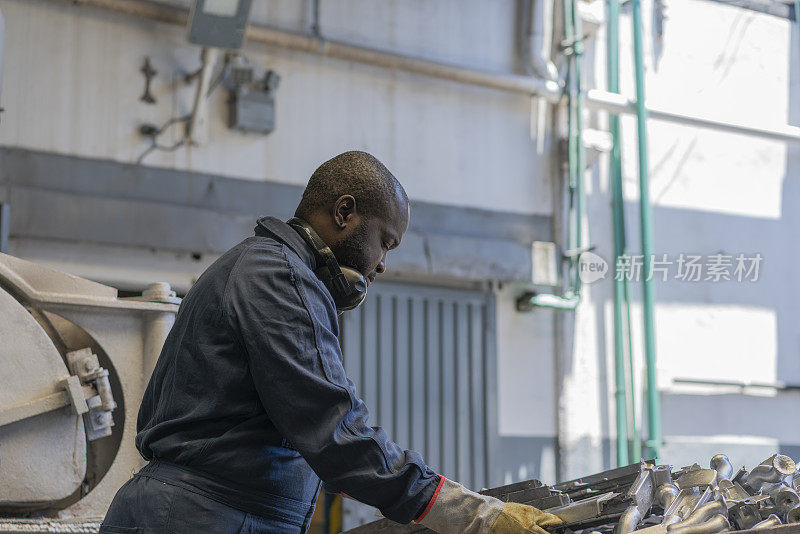 美国黑人工人在冶金工厂处理金属碎片