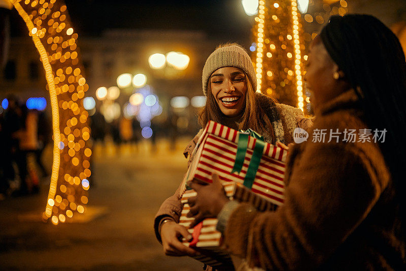 两个女人在户外拿着圣诞礼物