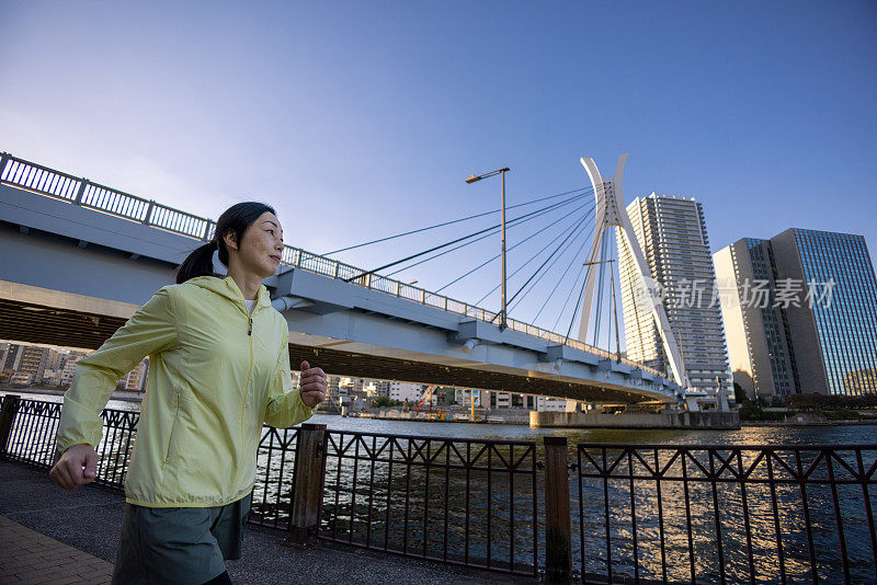 在城市的河畔奔跑的女人