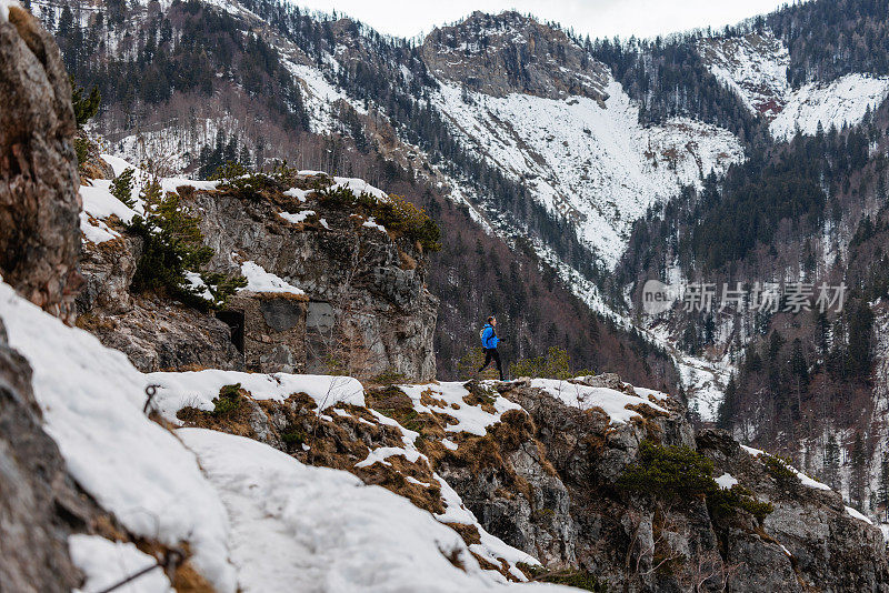 一个白种人在雪山上跑步