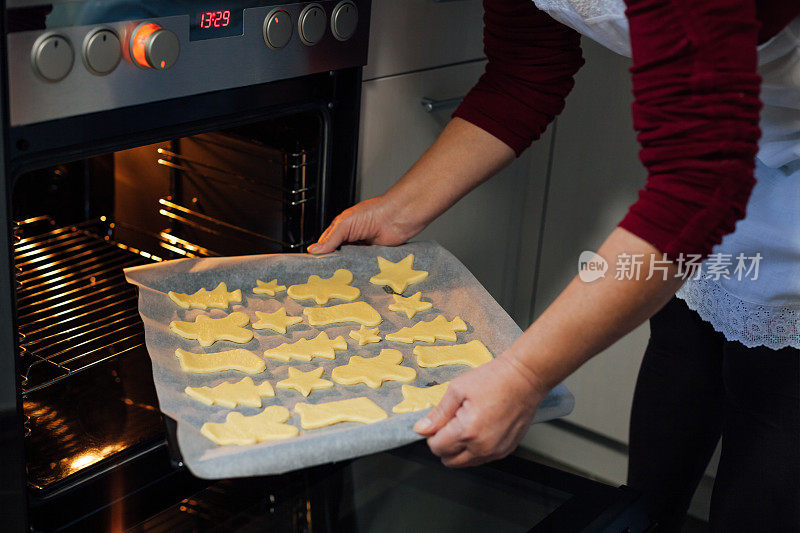 一个女人拿出烤好的饼干