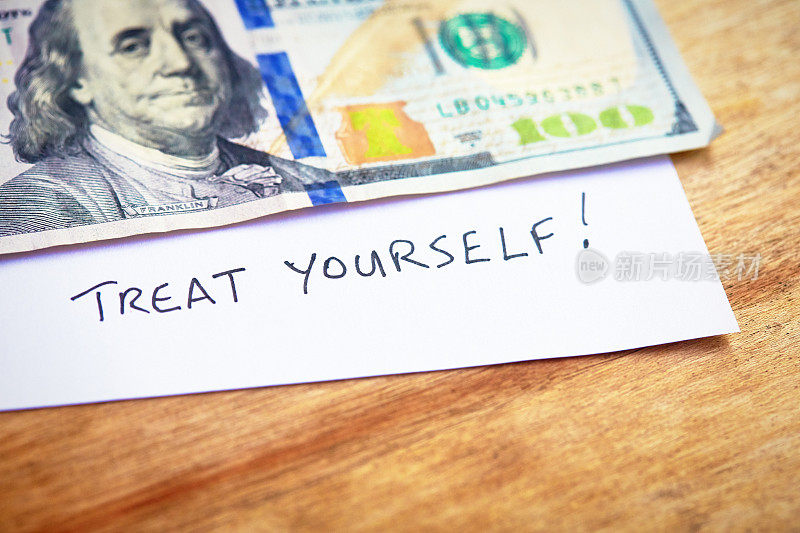 一张百元钞票下面的手写纸条上写道:犒赏自己
