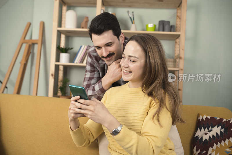 幸福的夫妻在家使用智能手机