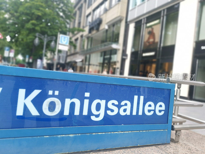 蓝色指示牌，上面写着Königsallee，指示公共交通的方向