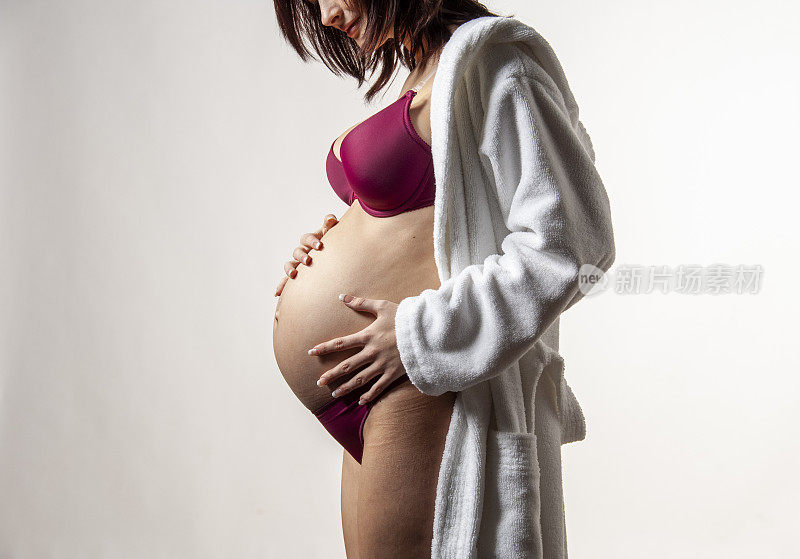 年轻的孕妇摸着她的肚子