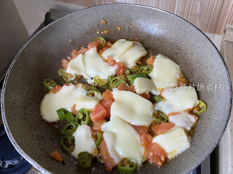 切好的青椒与奶酪片放入锅中煮饭
