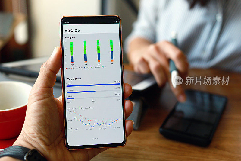 男人和女人用智能手机上的移动应用程序检查和分析股市数据