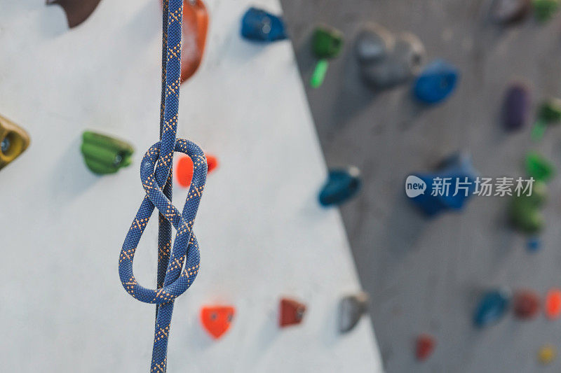 在室内攀岩墙上的彩色结实绳索上正确的安全结的特写。