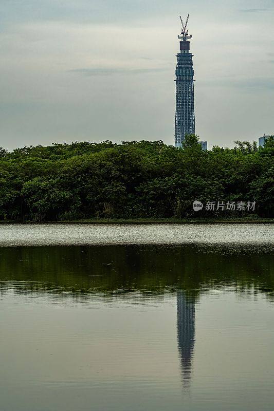 在中国青龙湖公园，摩天大楼和树木在水中的倒影