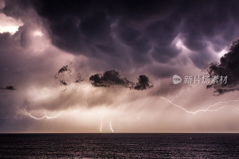 海洋上空的极端风暴伴随着降雨，闪电和黑暗的天空，云层