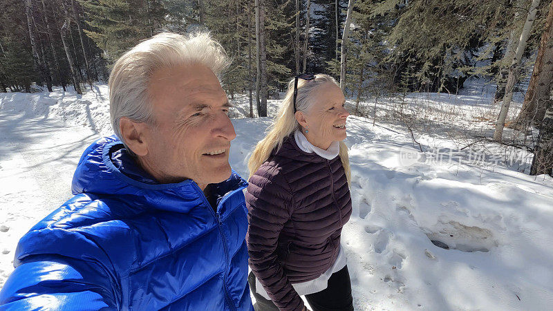 成熟的夫妇走在雪山小路上