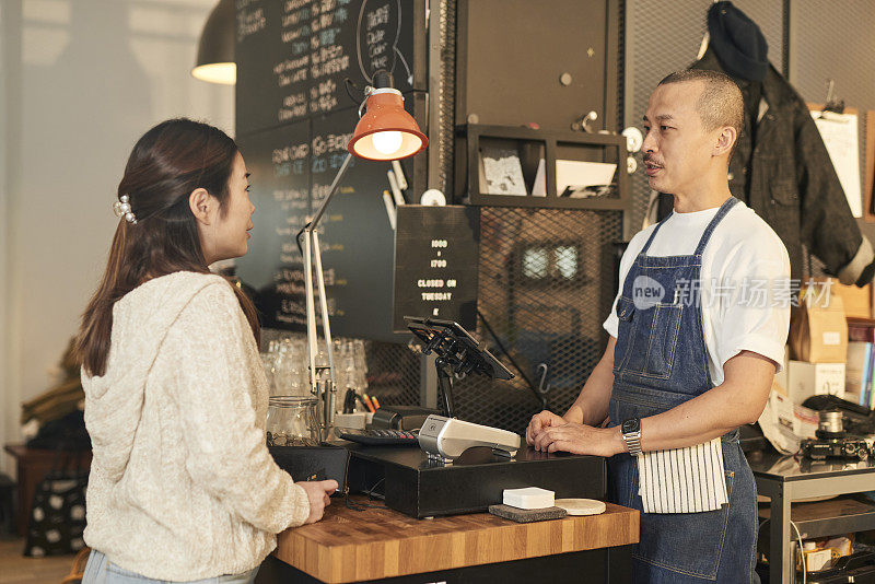 顾客在咖啡店用信用卡付款给店主，电子商务概念股