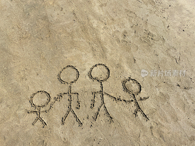 在阳光明媚的沙滩上，用木棍在潮湿的沙子上画的简笔画家庭特写图像，父母牵着孩子的手，兄弟姐妹，成年人不牵着手，高处的观点，分离和离婚的概念