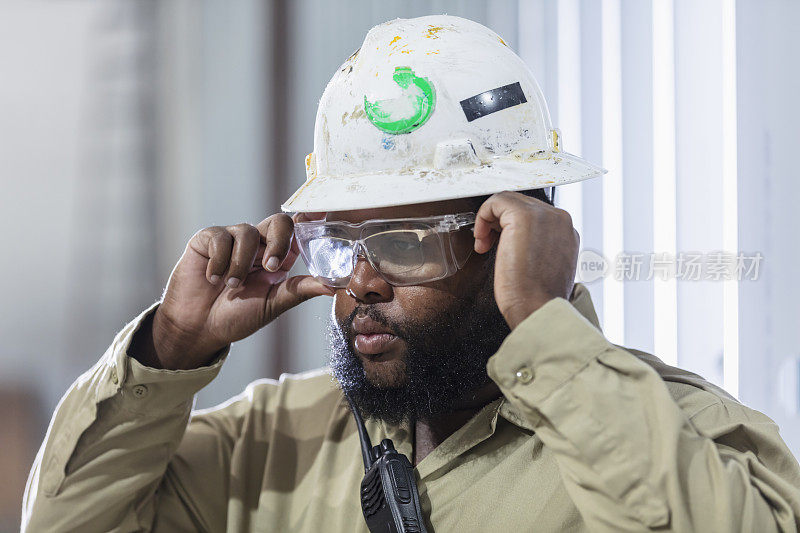 黑人建筑工人戴上防护眼镜