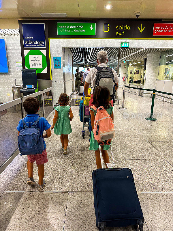 在葡萄牙度假旅行后，一家人在机场出口处的形象