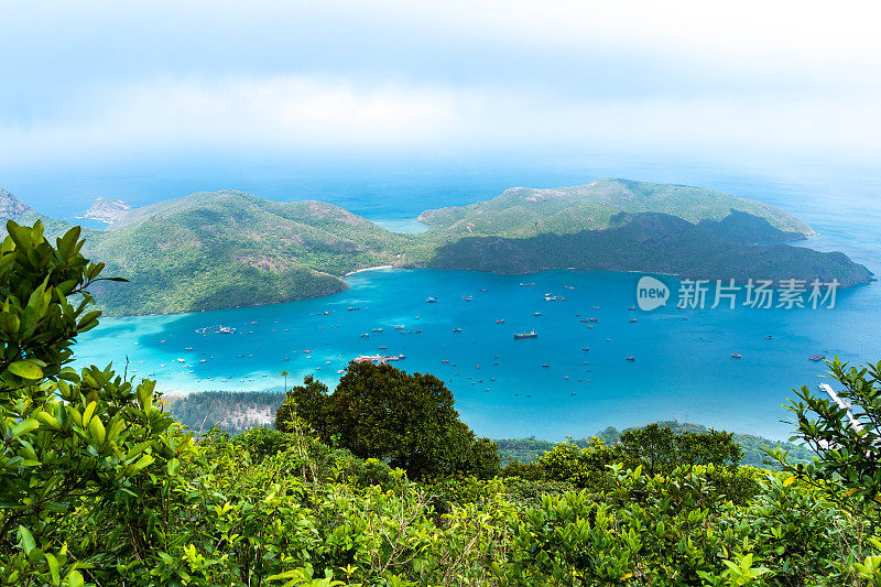 越南孔岛本丹港，湛蓝的大海，蓝天山和五颜六色的船只。