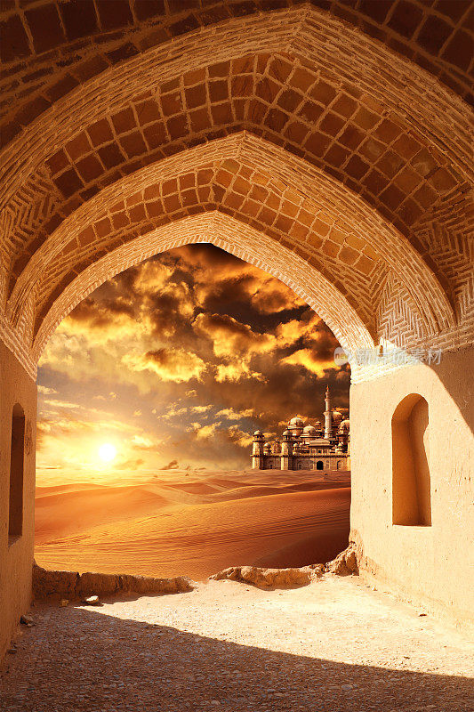 沙漠入口处的古老拱门。透过石拱可以看到沙丘和神话般的失落之城。美丽的沙漠景观，沙丘和神秘的东方城堡