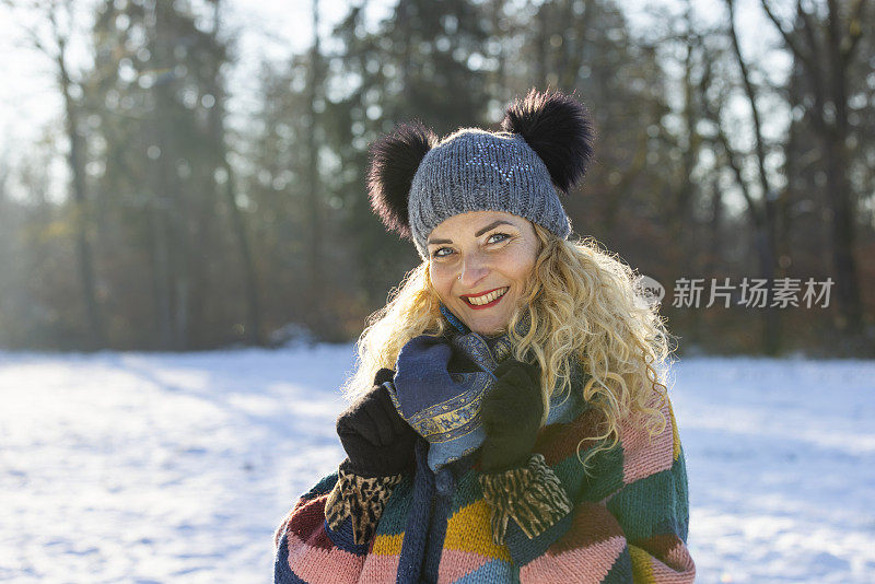 幸福的女人在冬天森林附近的白雪皑皑的草地