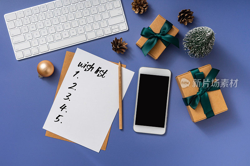 圣诞节和新年背景与智能手机，愿望清单和圣诞装饰，俯视图。