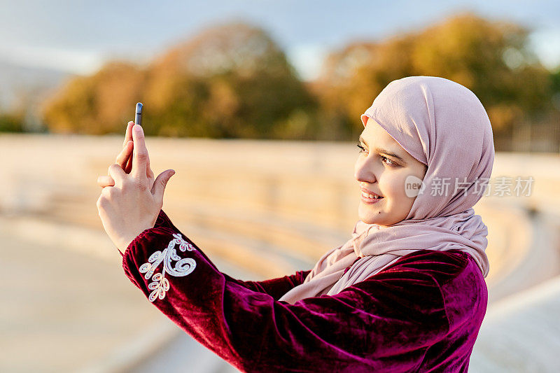一位穆斯林妇女正在用她的手机拍照