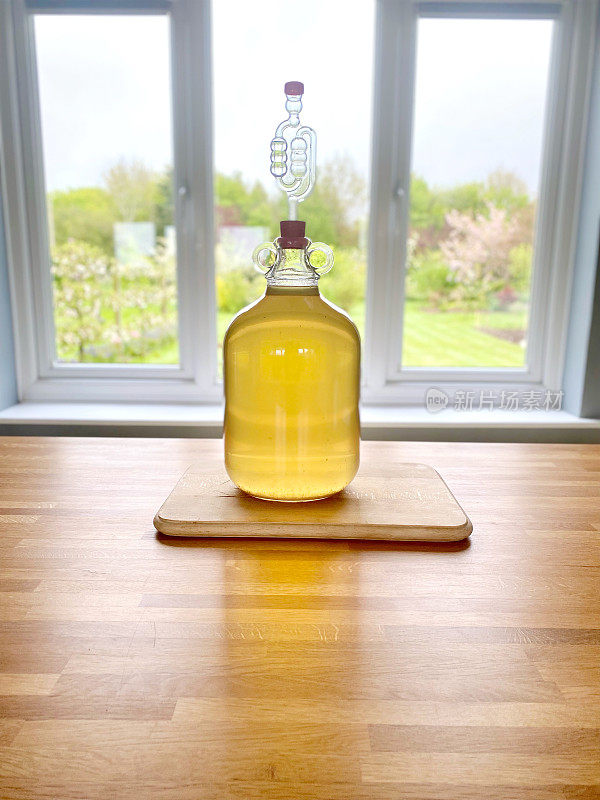 自家酿造的荨麻酒，在厨房里的半桶或玻璃瓶里发酵，对着一扇乡村景色的窗户