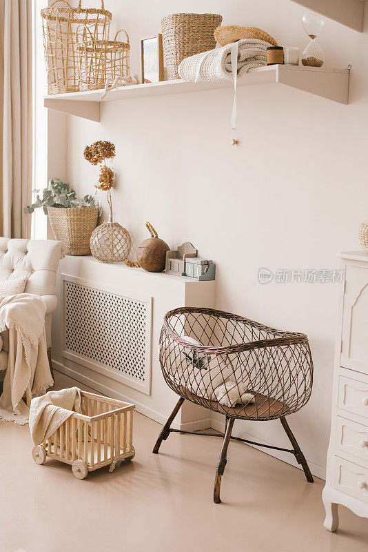 儿童房内部为婴儿准备的儿童柳条床，采用斯堪的纳维亚风格的浅米色调