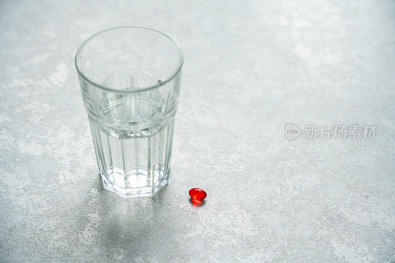 红色药丸和一杯水放在桌子上，复制右边的空间