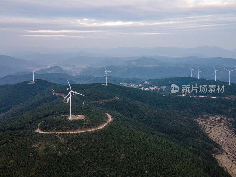 一组风力涡轮机在一个阳光明媚的山上