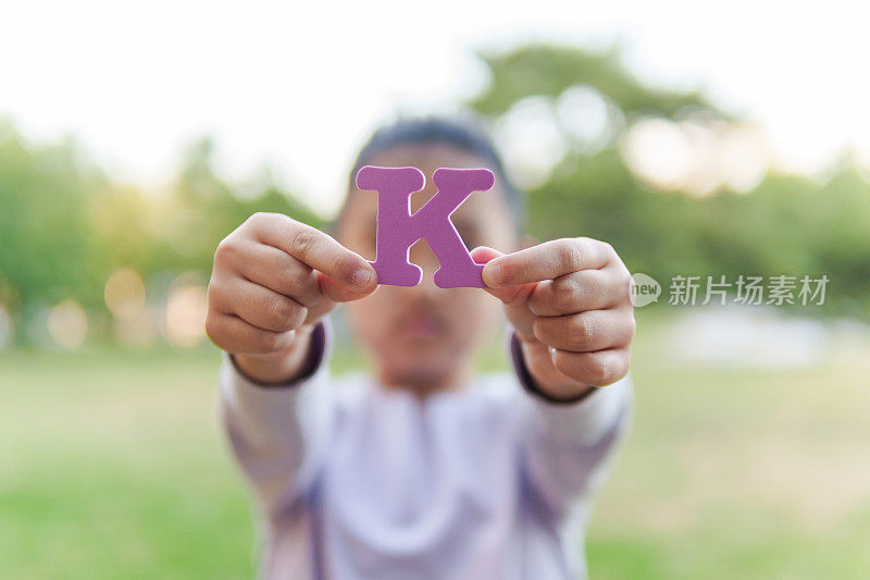 小孩拿着字母“K”