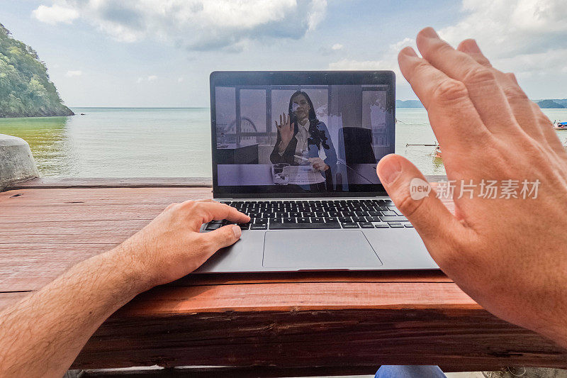 在泰国的海滩酒吧里，一名年轻男子与一名女同事进行视频通话