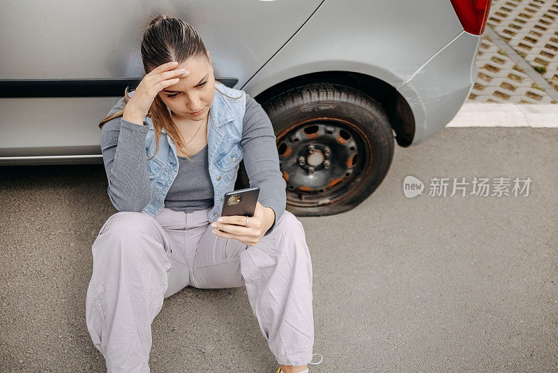 一名妇女车胎漏气，正在用手机求救