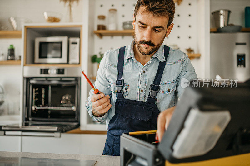 熟练的男性木匠，熟练地使用一系列专业工具安装和修理烤箱