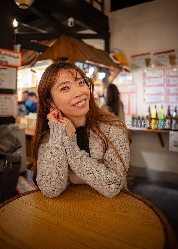 女游客在日本居酒屋风格的美食广场等待食物