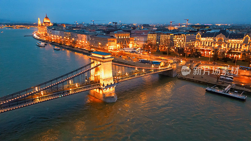 夜间，匈牙利布达佩斯，多瑙河上的塞切尼吊桥以国会大厦为背景