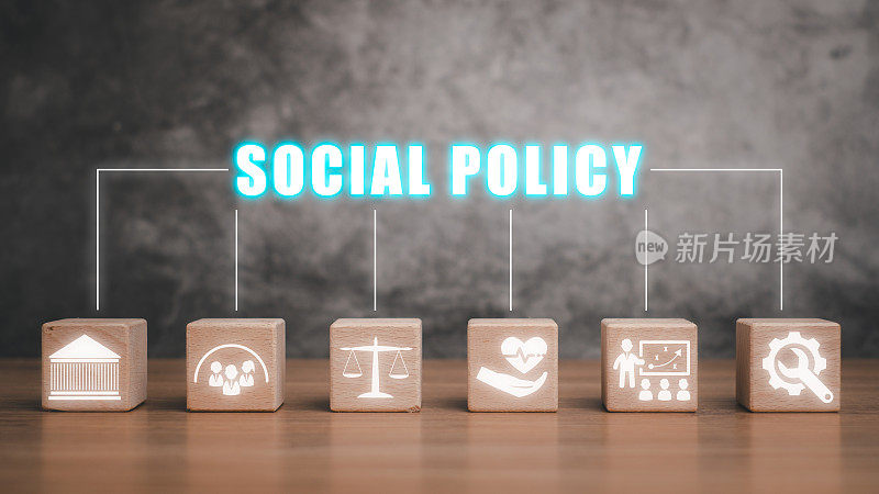 社会政策概念，桌面上的木块，虚拟屏幕上的社会政策图标。