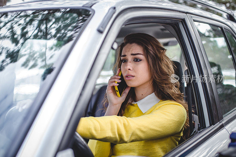 年轻压力大的女人一边打电话一边开车