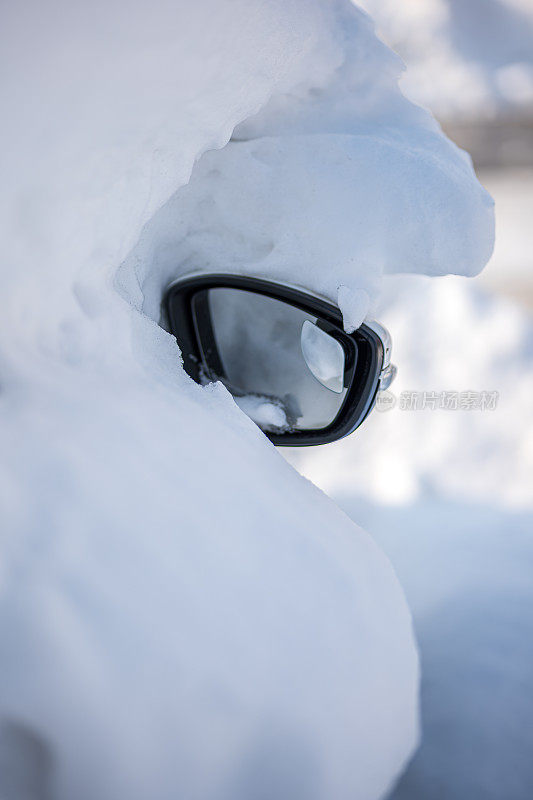 被大雪困住的汽车一动不动地停在房子院子里的雪地里