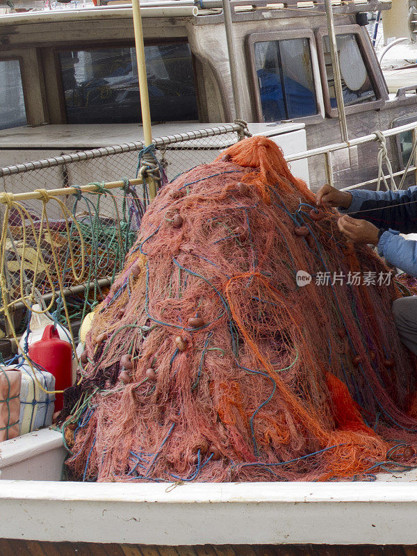 渔民在船上手工修补传统渔网
