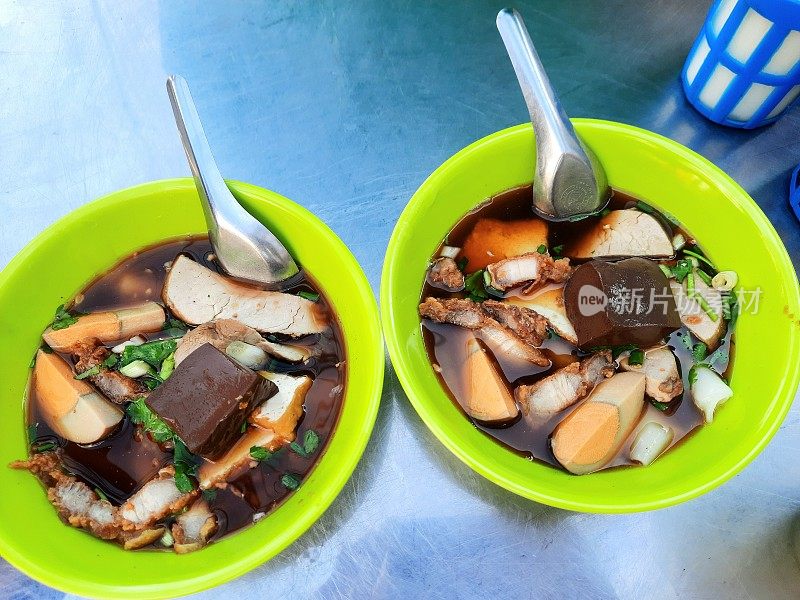 浓汤面配香脆五花肉和水煮蛋——曼谷街头小吃。