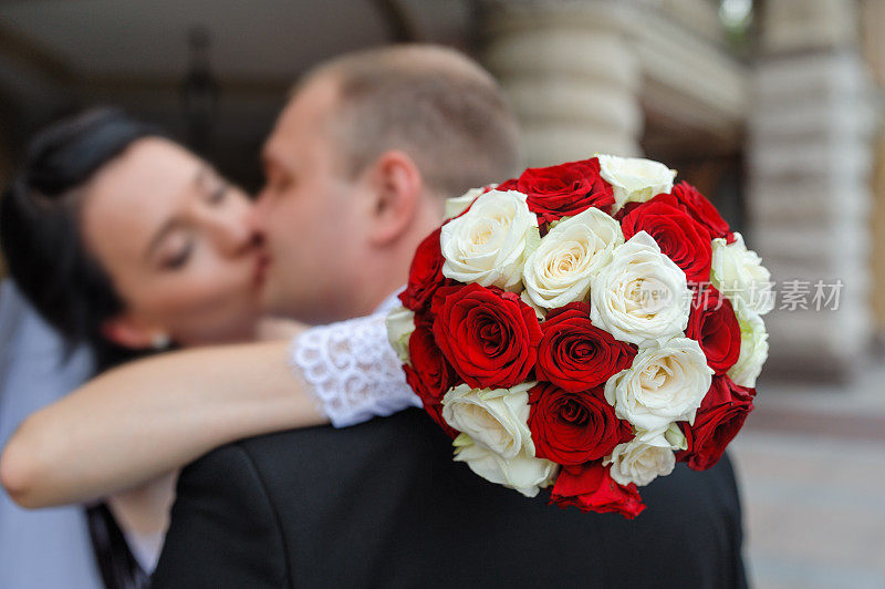 新娘和新郎在一束花前接吻