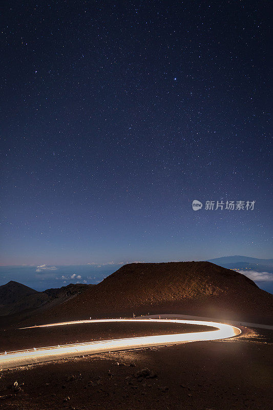日出时的哈雷阿卡拉火山口和汽车轨迹灯